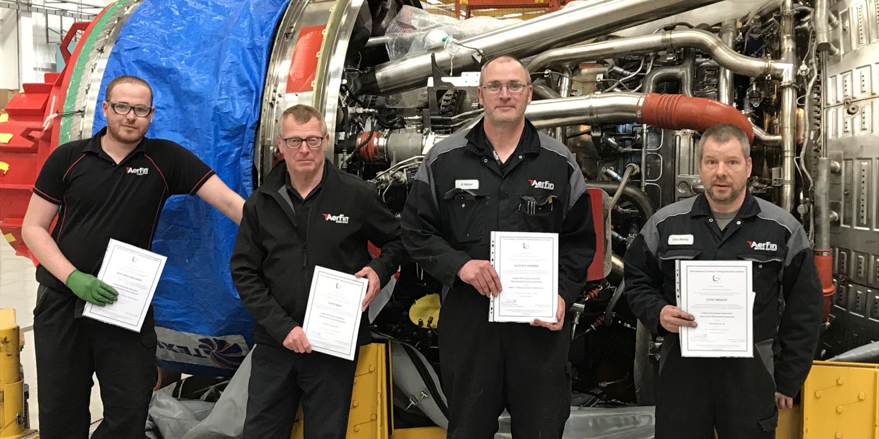 Aerfin staff holding certificates in their HQ